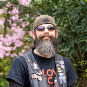 Donovan Allen stands in front of a flowering bush